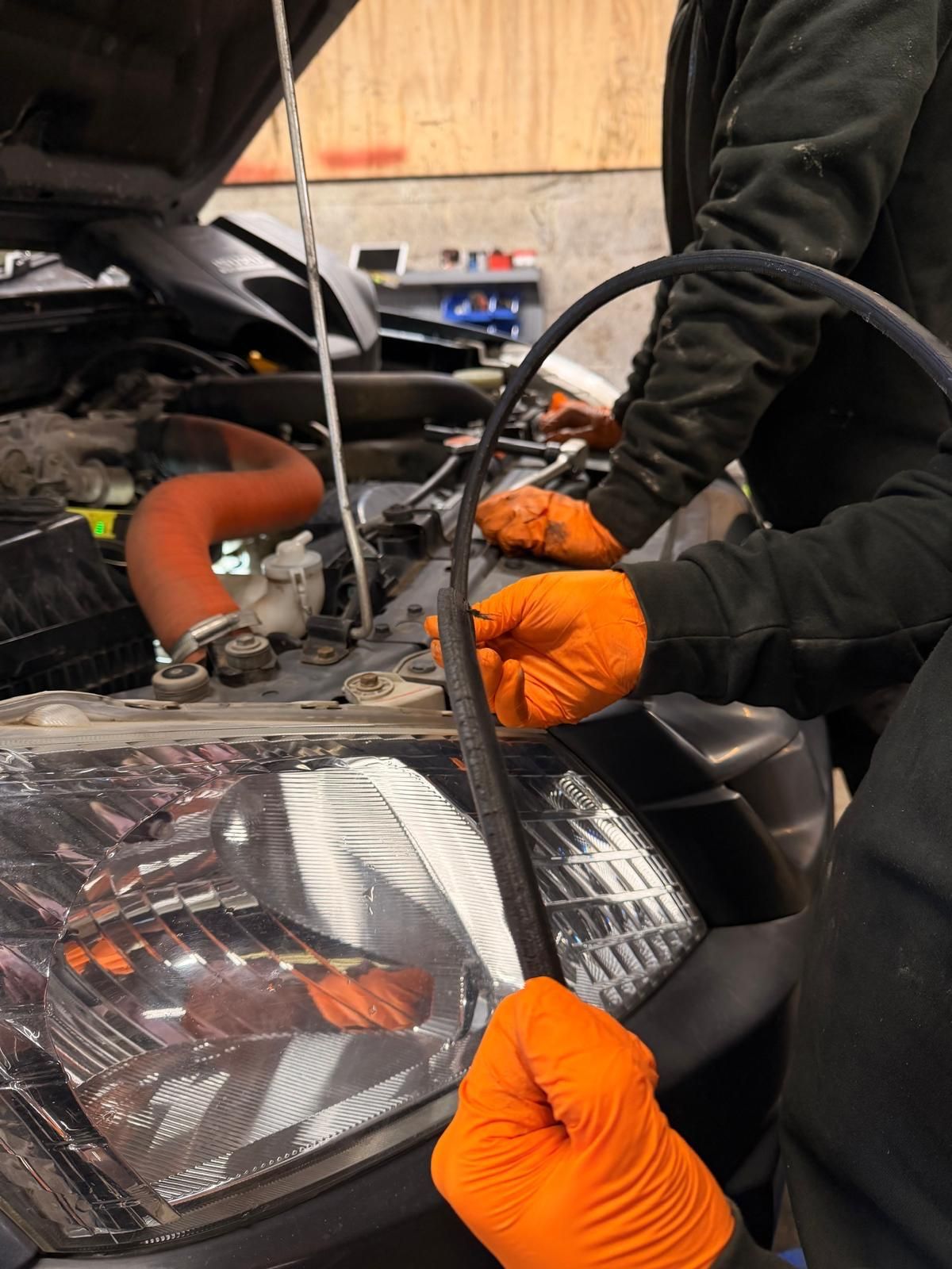Technician inspecting an auxiliary drive belt removed from an engine