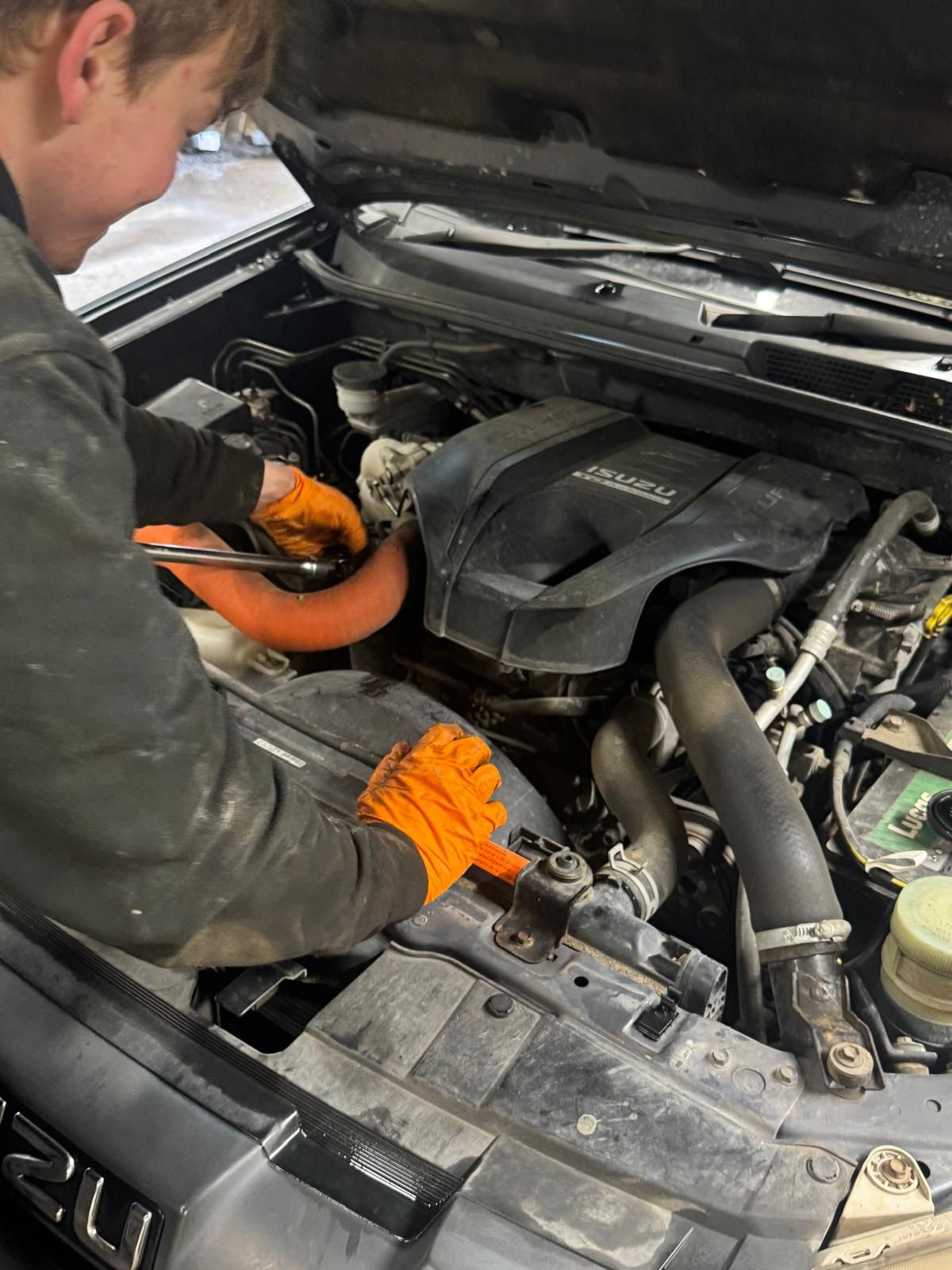 Technician working on an Isuzu engine bay at Southern VSR